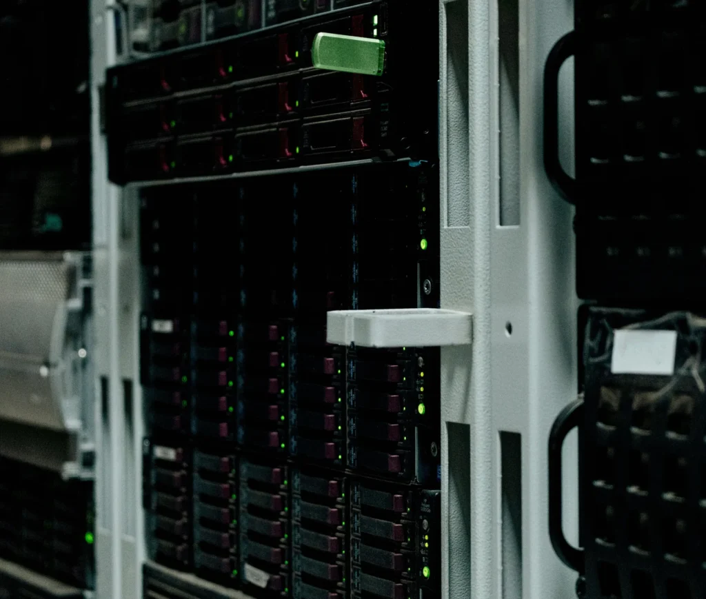 Close up of a server rack with multiple black server units, green indicator lights, and various slots and panels, located in a data centre environment, designed to ensure reliable file backup and secure data management within the specified storage limit.