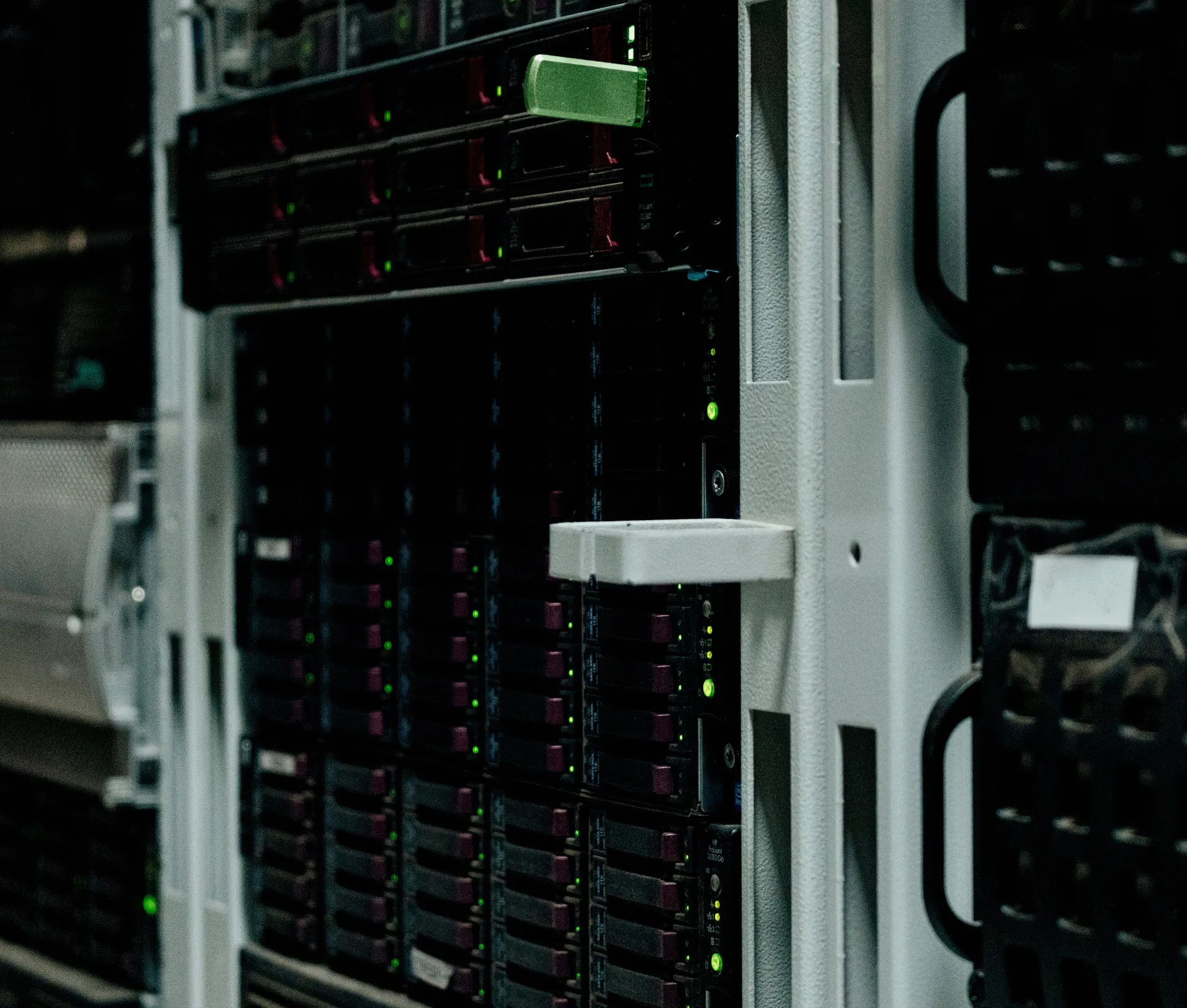 Close up of a server rack with multiple black server units, green indicator lights, and various slots and panels, located in a data centre environment, designed to ensure reliable file backup and secure data management within the specified storage limit.