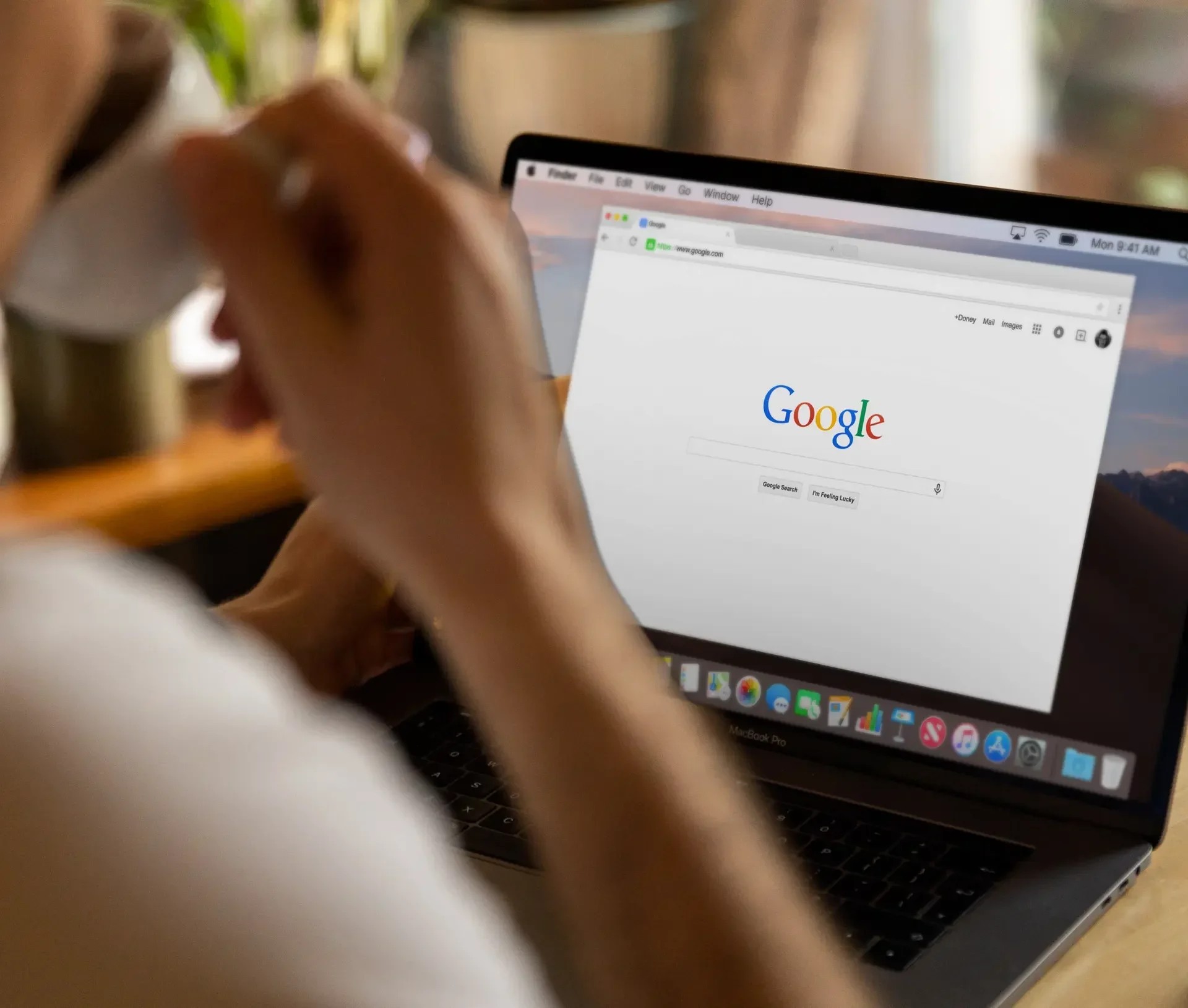 A person sits at a desk using a laptop with the google chrome 2025 homepage open on the screen, highlighting the latest innovations in chrome ai expansion.