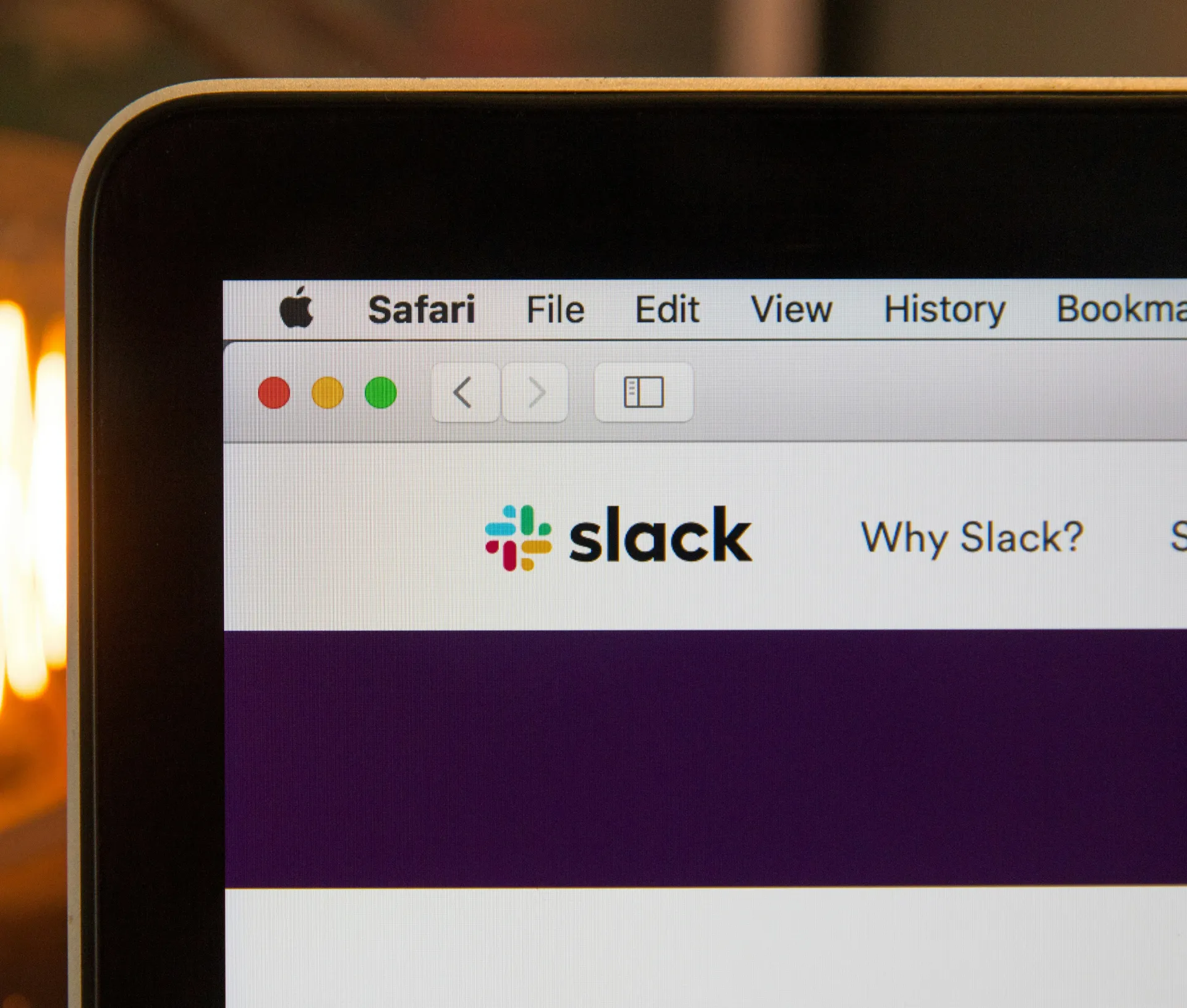 A close up of a laptop screen shows the Safari browser open to the Slack website. The Slack logo and menu options are visible in the browser window, highlighting a focus on data security as users manage messaging habits and sensitive client files.