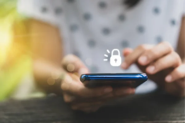 A person using a smartphone with a digital padlock icon, highlighting mobile device security and the importance of protecting key risks for business privacy and data protection.