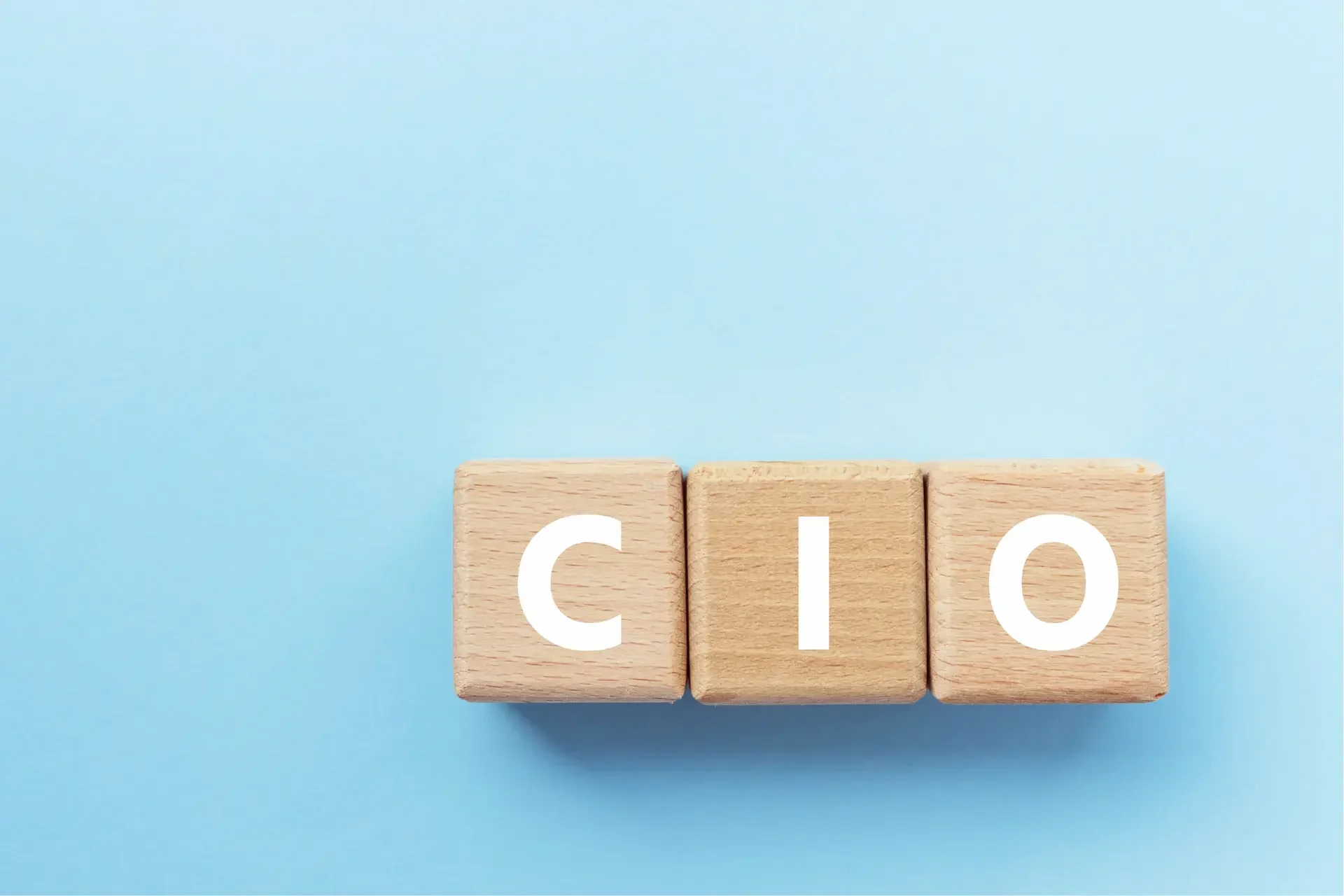 Three wooden blocks on a light blue background display the letters c, i, and o in white uppercase font—perfect for illustrating how a cio can fix an it mess with clarity and leadership.