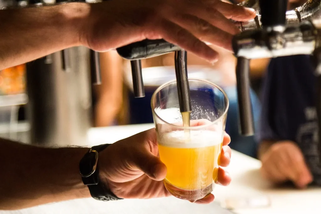 A person is filling a glass with beer from a tap at Camden Town Brewery.