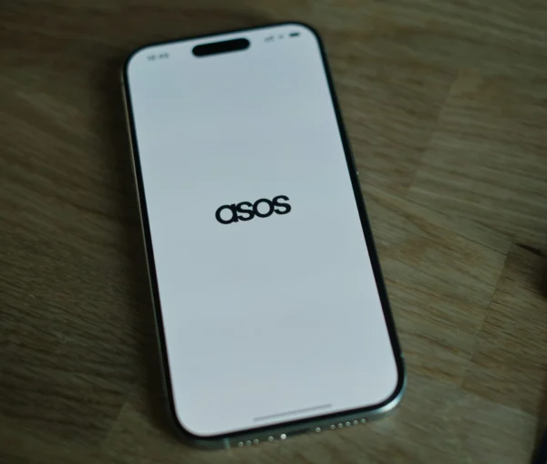 A smartphone displaying the ASOS logo, a company recently impacted by a data breach, on a white screen.