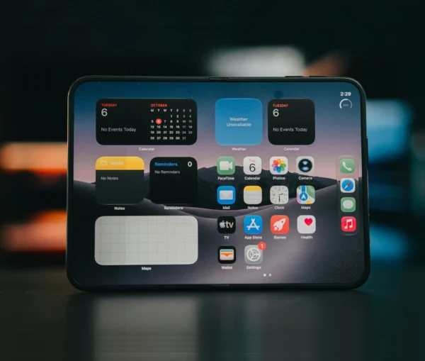 An iPhone Duo foldable smartphone displaying a home screen with various app icons, including Calendar, Weather, Notes, and Maps widgets.