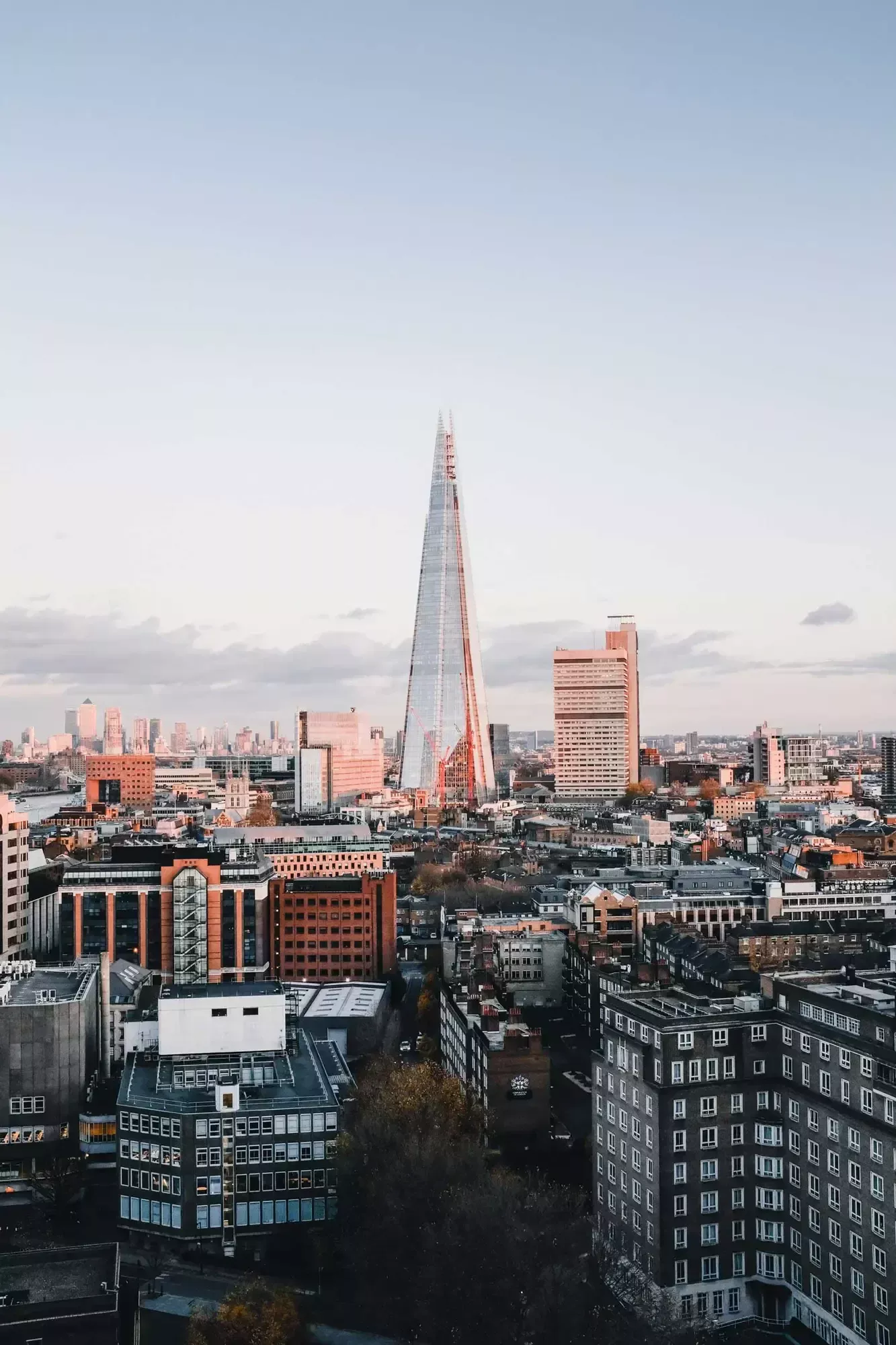 A cityscape of London at sunset with the Shard skyscraper prominently towering above, mirroring the ambitions of financial services nestled below.