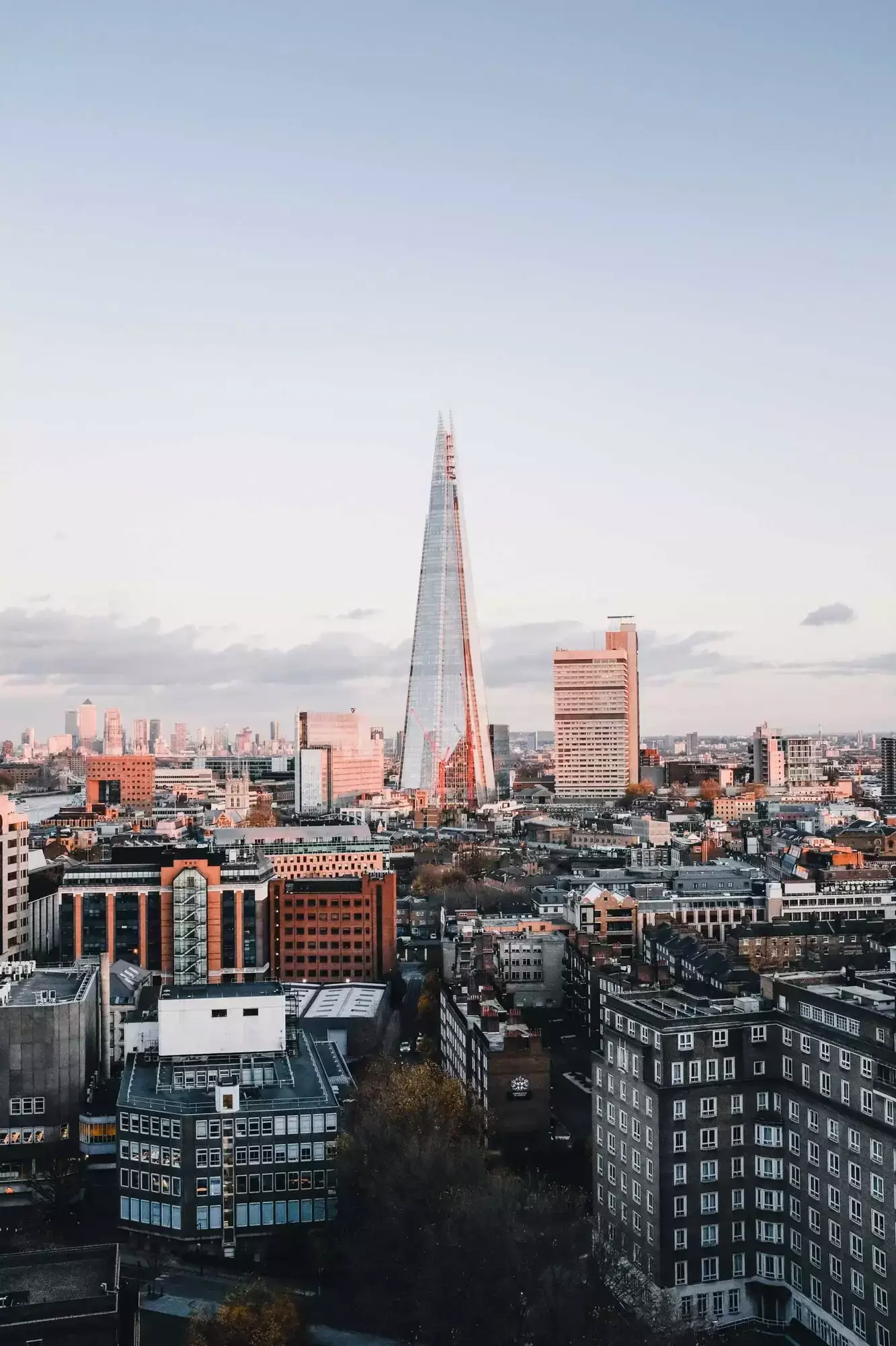 A cityscape of London at sunset with the Shard skyscraper prominently towering above, mirroring the ambitions of financial services nestled below.