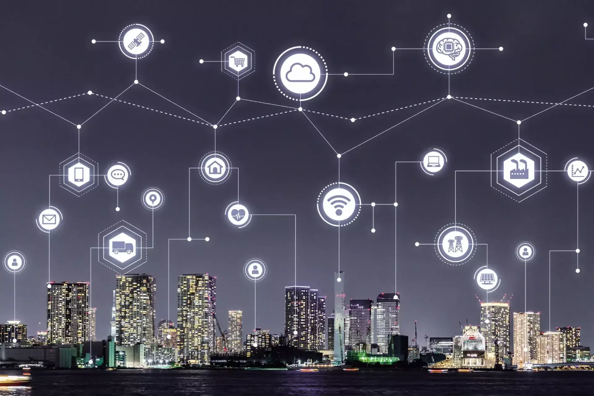 A city skyline at night with illuminated buildings, overlaid with digital network icons representing smart automation and enhanced business efficiency through advanced connectivity.